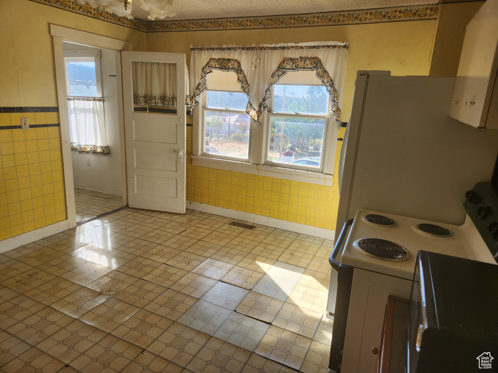 Kitchen featuring light tile floors and range