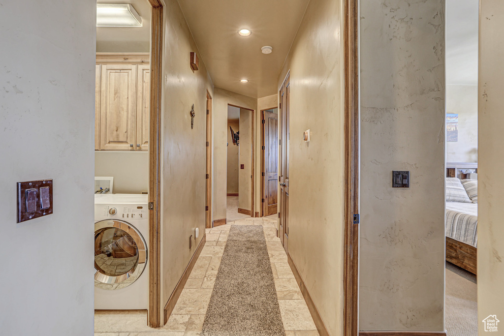Washroom featuring washer / clothes dryer, light tile floors, and cabinets