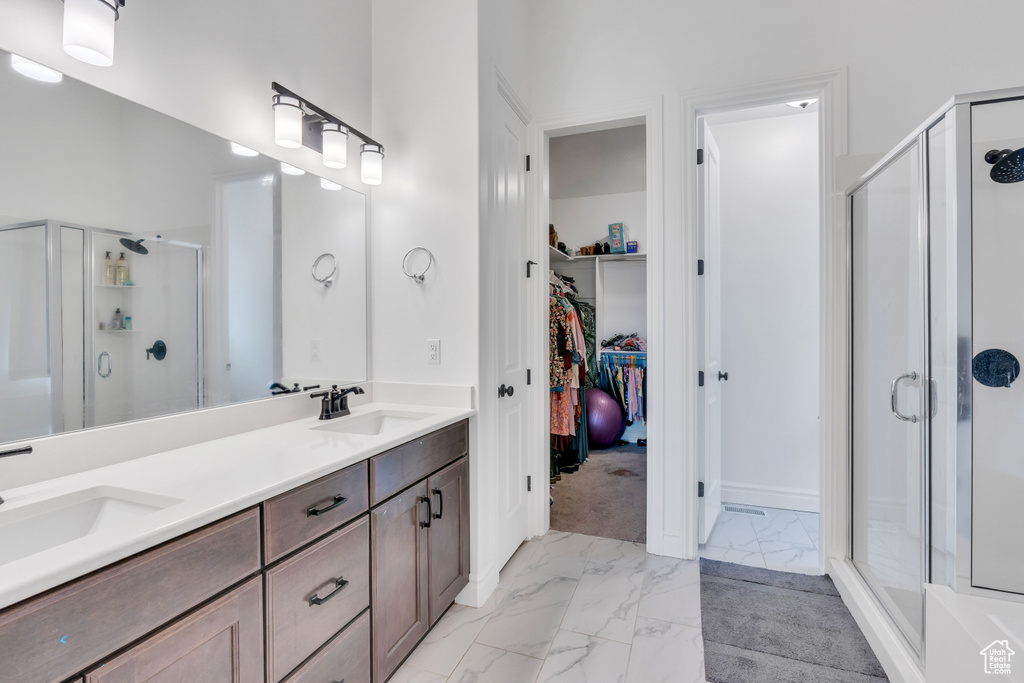 Bathroom with dual bowl vanity, tile floors, and walk in shower
