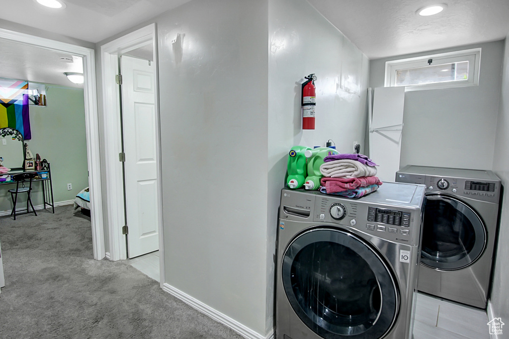 Laundry room with light carpet and separate washer and dryer