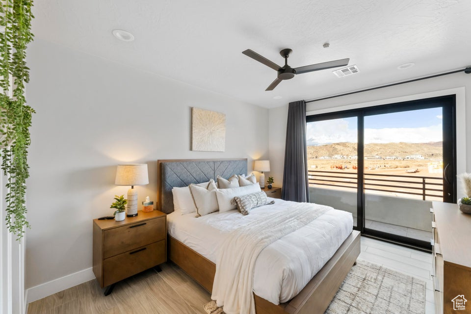 Bedroom featuring light hardwood / wood-style floors, ceiling fan, and access to exterior