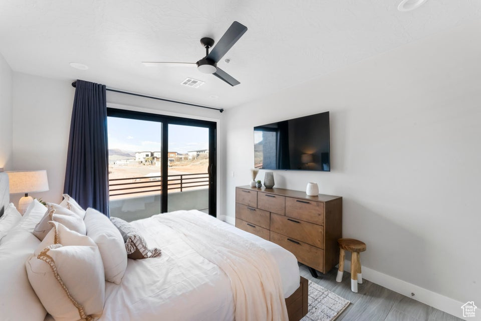 Bedroom with light hardwood / wood-style flooring, ceiling fan, and access to outside