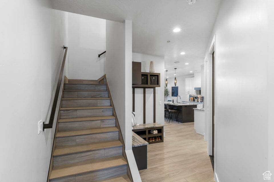 Stairway featuring light hardwood / wood-style flooring and sink