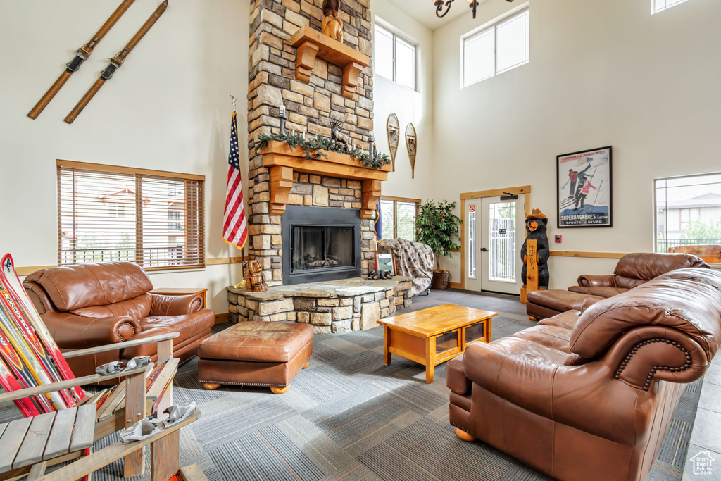 Living room featuring a high ceiling and a stone fireplace