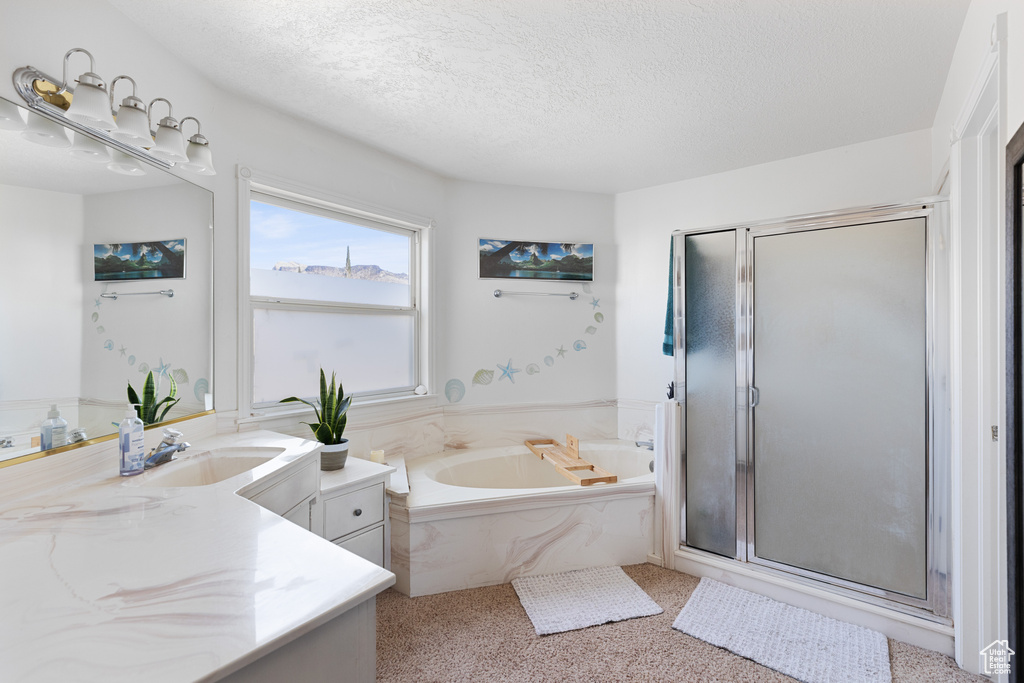 Bathroom featuring vanity, a textured ceiling, and plus walk in shower