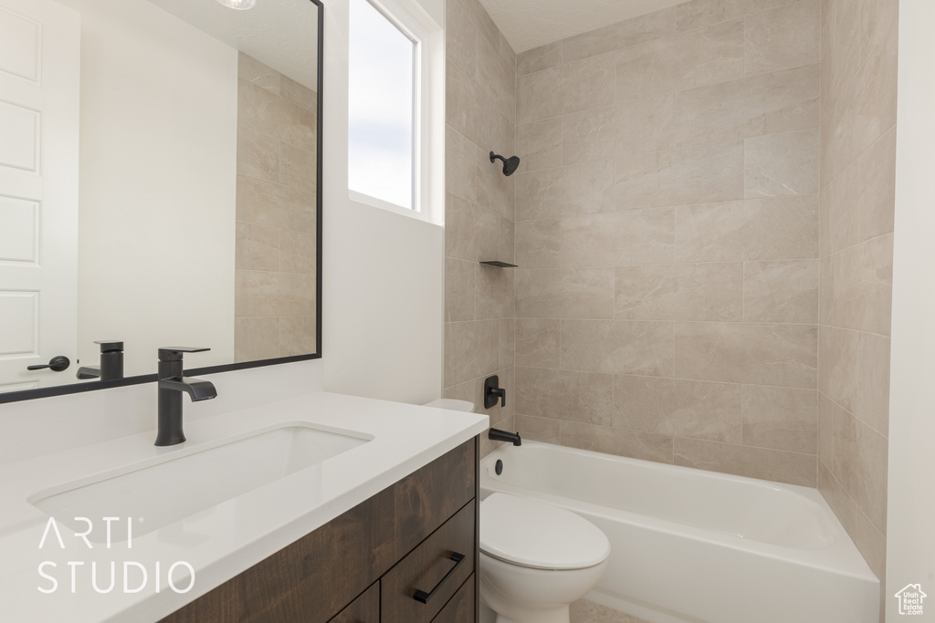 Full bathroom featuring vanity, toilet, and tiled shower / bath