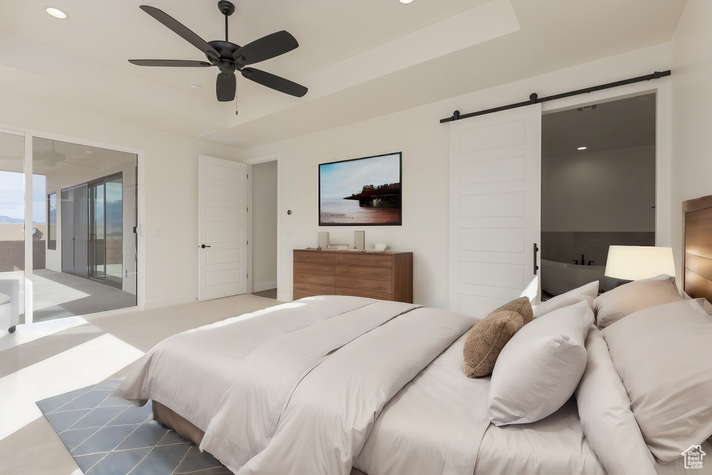 Bedroom with light colored carpet, a barn door, ceiling fan, and access to outside