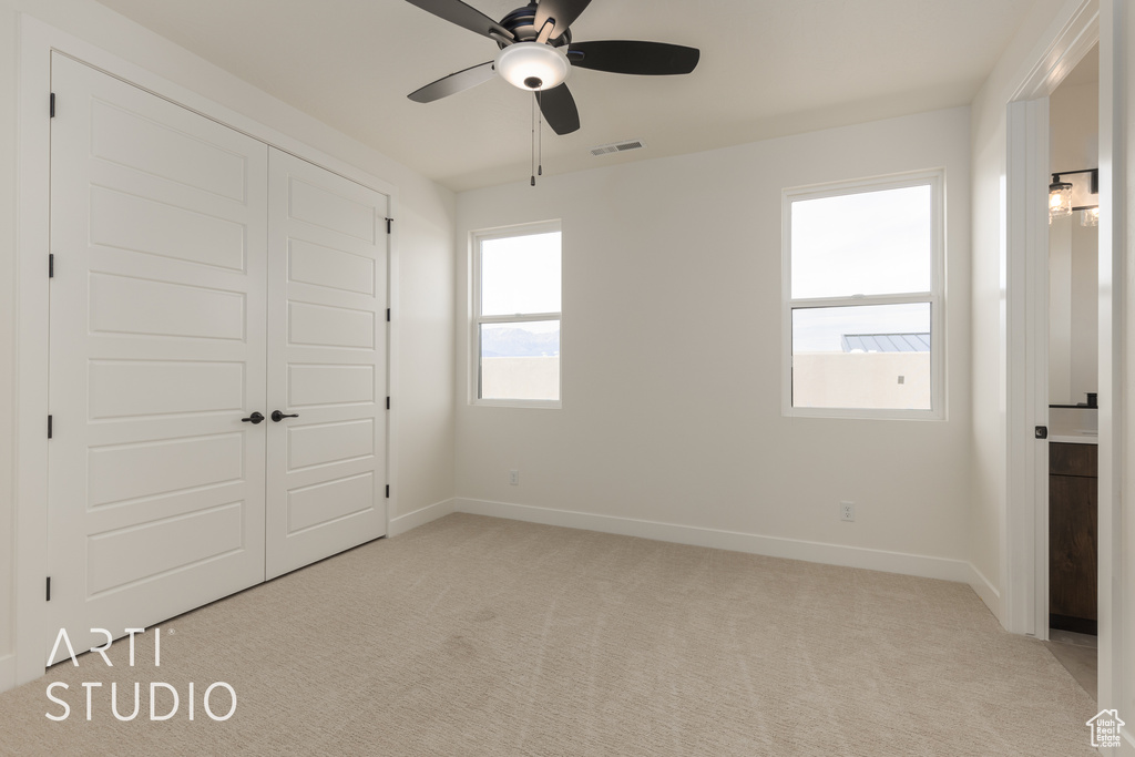 Unfurnished bedroom with a closet, ceiling fan, and light colored carpet