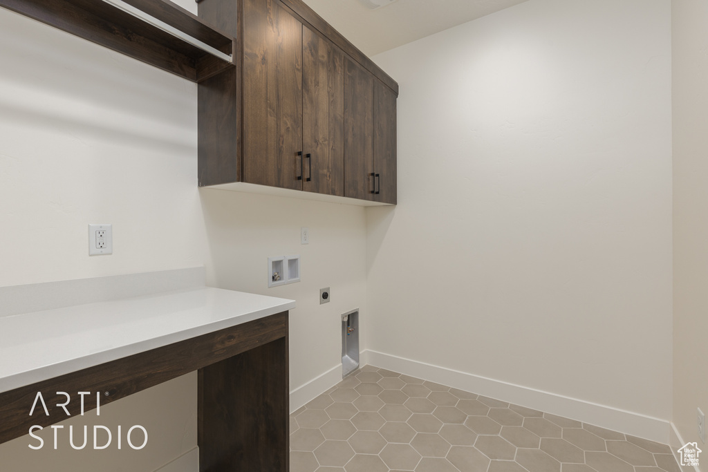 Laundry room with hookup for a washing machine, cabinets, electric dryer hookup, and light tile floors