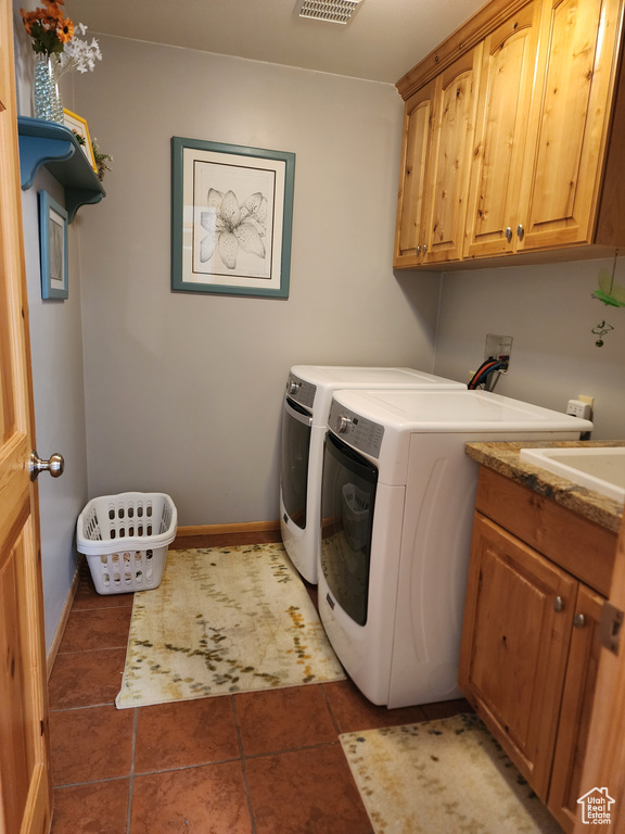 Clothes washing area with washer hookup, cabinets, sink, separate washer and dryer, and tile floors