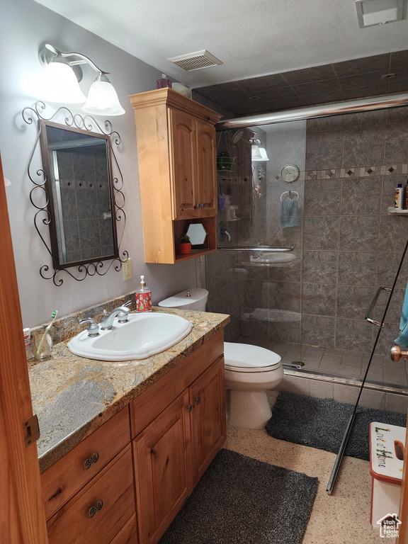 Bathroom featuring toilet, an enclosed shower, and oversized vanity