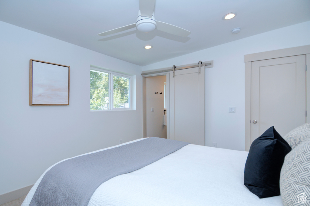 Bedroom featuring ceiling fan and a barn door