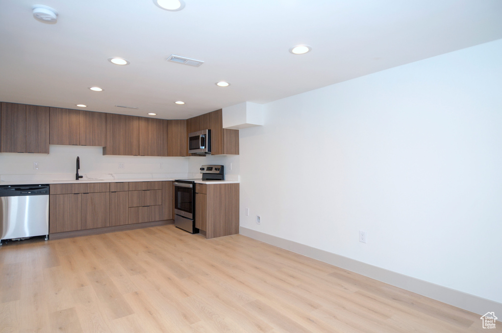 Kitchen featuring light hardwood / wood-style floors, sink, and appliances with stainless steel finishes
