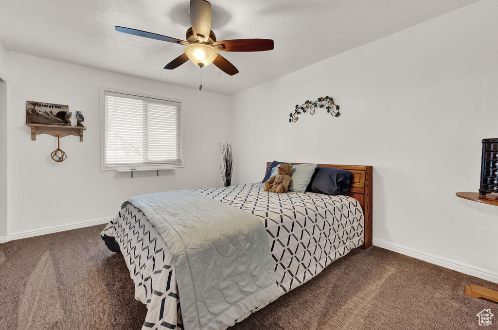 Bedroom with dark carpet and ceiling fan