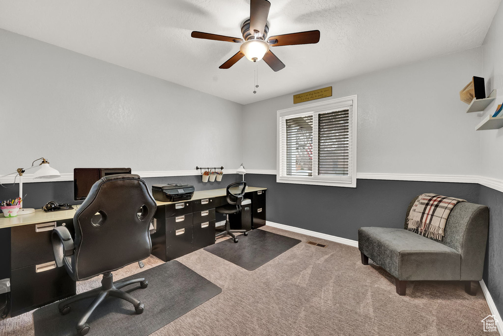 Home office featuring dark carpet and ceiling fan