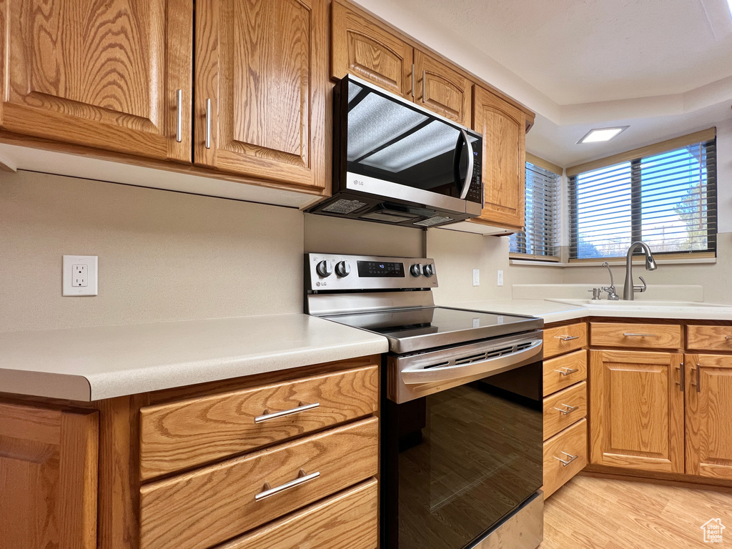 Kitchen featuring light hardwood / wood-style floors, stainless steel appliances, and sink