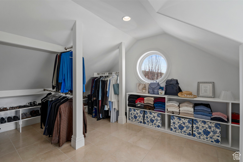 Walk in closet with vaulted ceiling and light tile floors