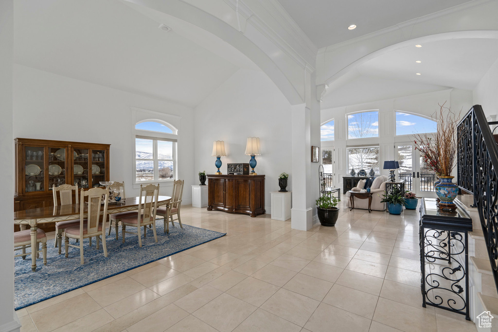 Dining area with light tile floors, a healthy amount of sunlight, and high vaulted ceiling
