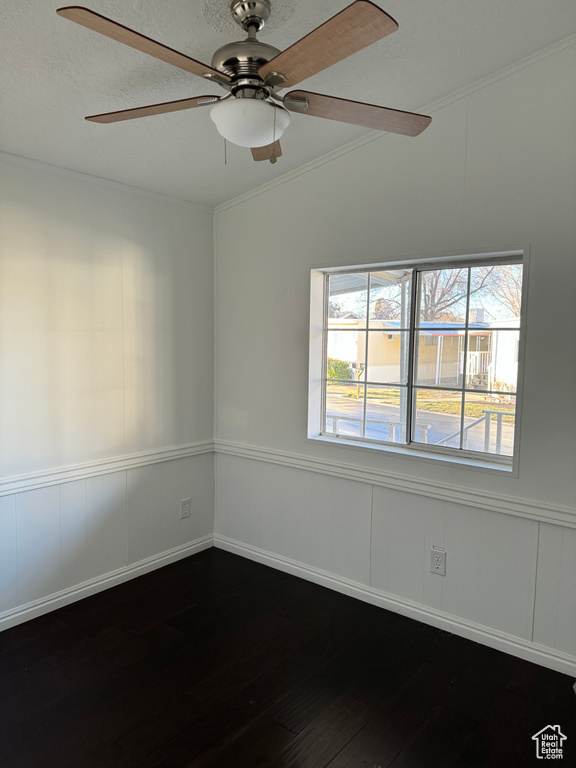 Spare room with dark hardwood / wood-style flooring, ceiling fan, vaulted ceiling, and ornamental molding