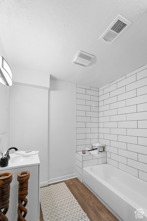 Bathroom featuring vanity, hardwood / wood-style floors, and a textured ceiling