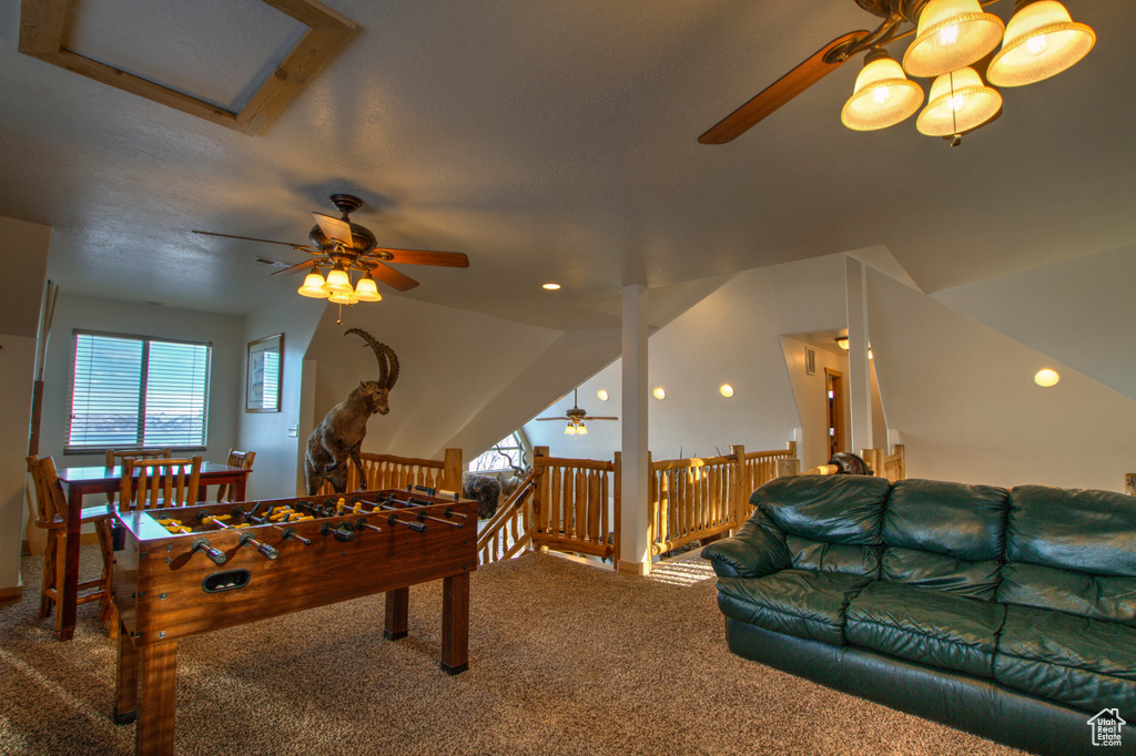 Rec room with lofted ceiling, ceiling fan, and carpet