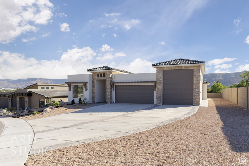 View of front of property with a garage and a mountain view