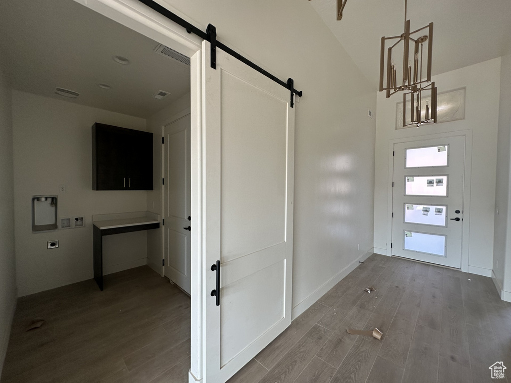 Entrance foyer featuring a barn door and wood-type flooring