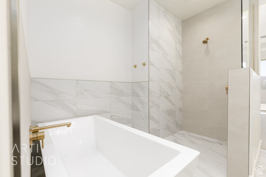 Bathroom with shower with separate bathtub and tile walls