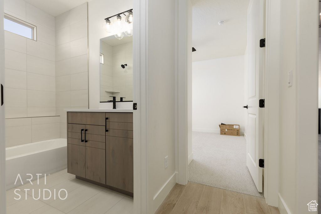 Bathroom featuring shower / tub combination, hardwood / wood-style flooring, and vanity