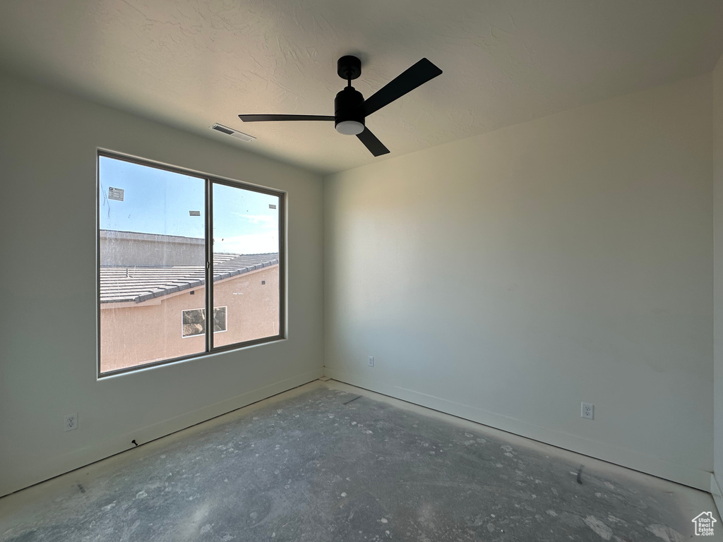 Unfurnished room featuring concrete floors and ceiling fan