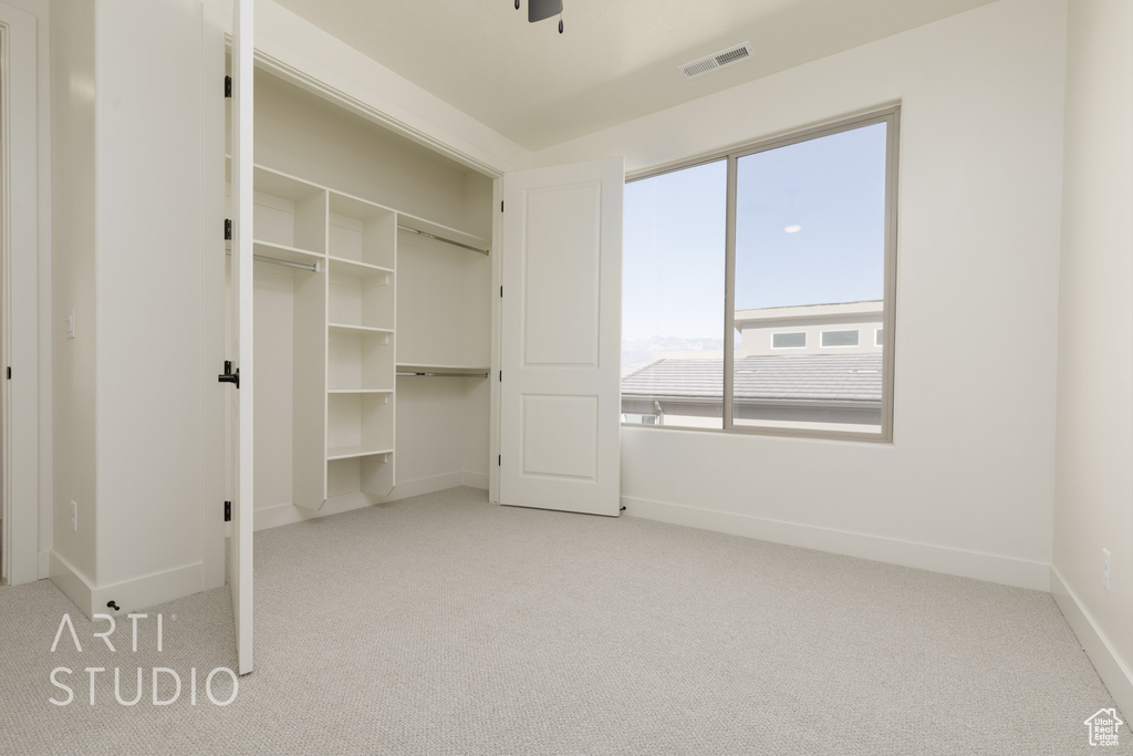 Unfurnished bedroom with light carpet and a closet