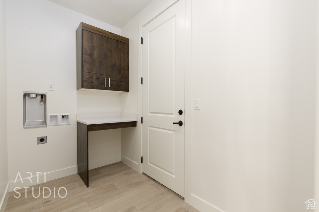 Laundry room with washer hookup, hookup for an electric dryer, light hardwood / wood-style floors, and cabinets