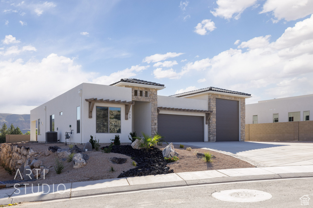 View of front of property with cooling unit and a garage