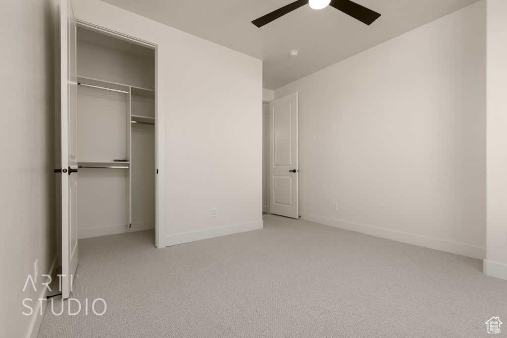 Unfurnished bedroom featuring a closet, light carpet, and ceiling fan