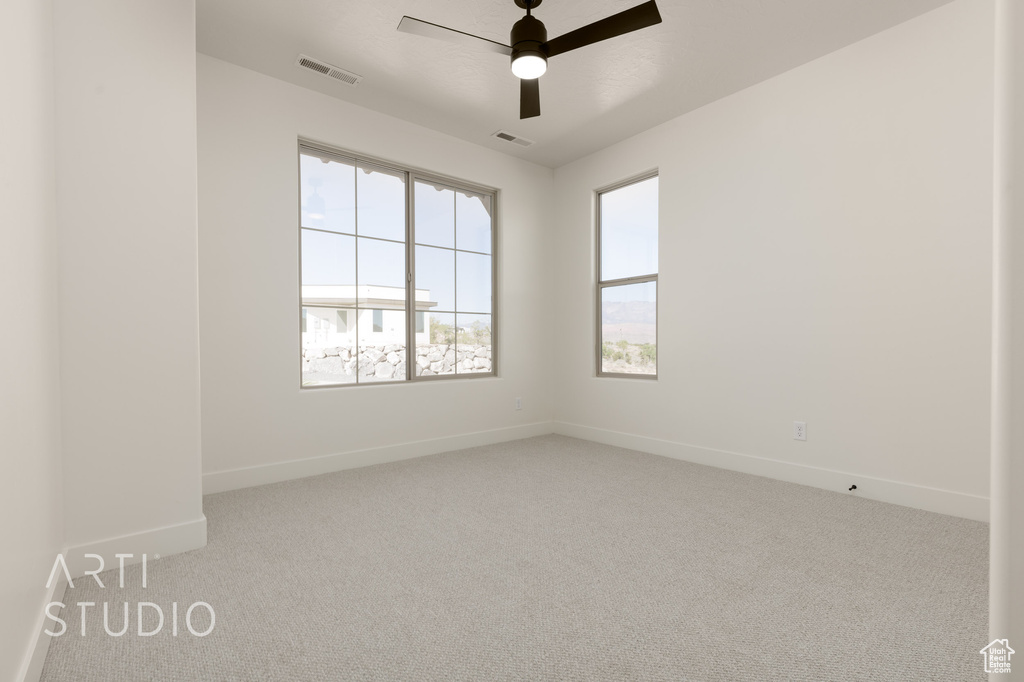 Empty room with light carpet and ceiling fan