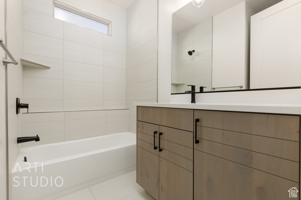 Bathroom featuring tiled shower / bath, vanity, and tile patterned floors