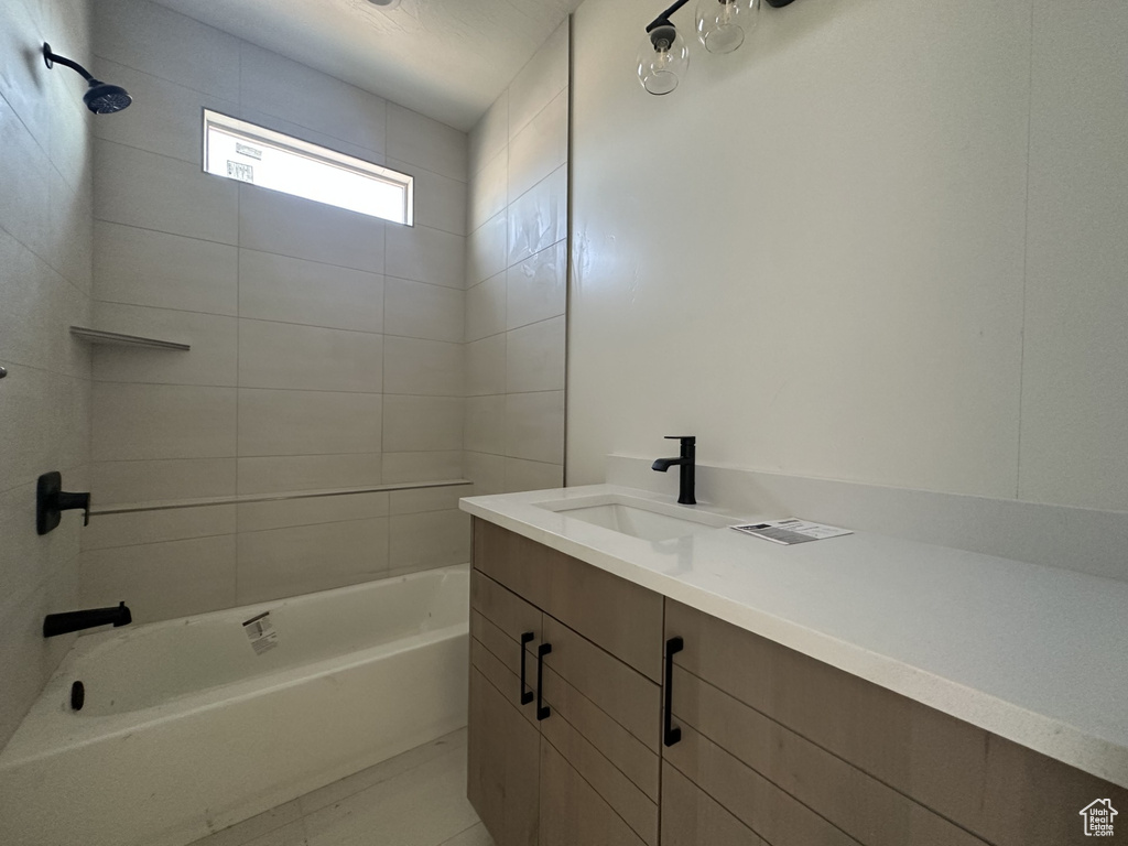 Bathroom featuring tiled shower / bath combo and vanity