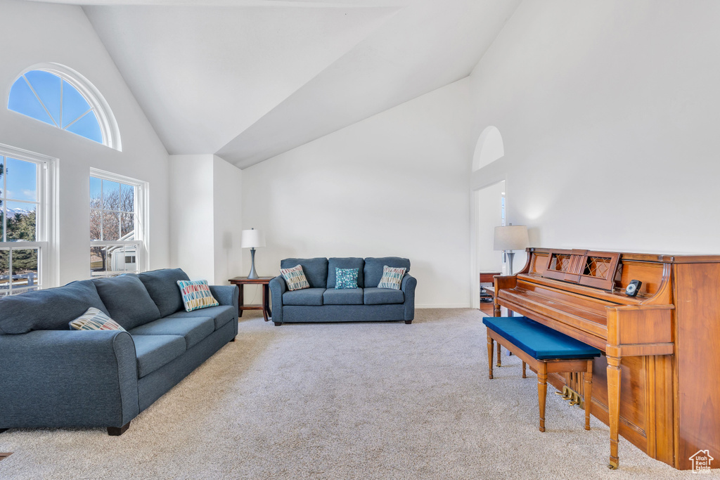 Living room featuring high vaulted ceiling and light colored carpet