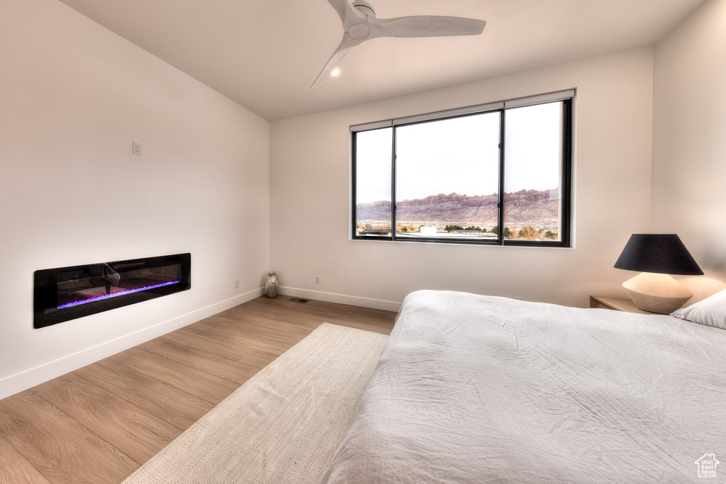 Bedroom featuring a mountain view, light hardwood / wood-style floors, and ceiling fan