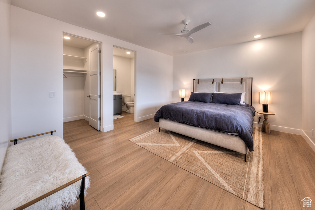 Bedroom with light hardwood / wood-style flooring, a closet, a walk in closet, and ceiling fan