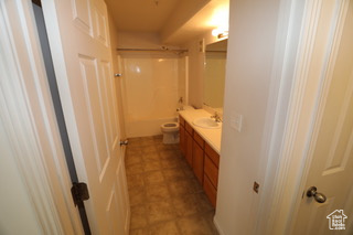 Full bathroom featuring large vanity,  shower combination, tile flooring, and toilet