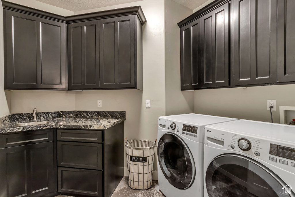 Laundry room with washer hookup, washer and clothes dryer, tile floors, sink, and cabinets