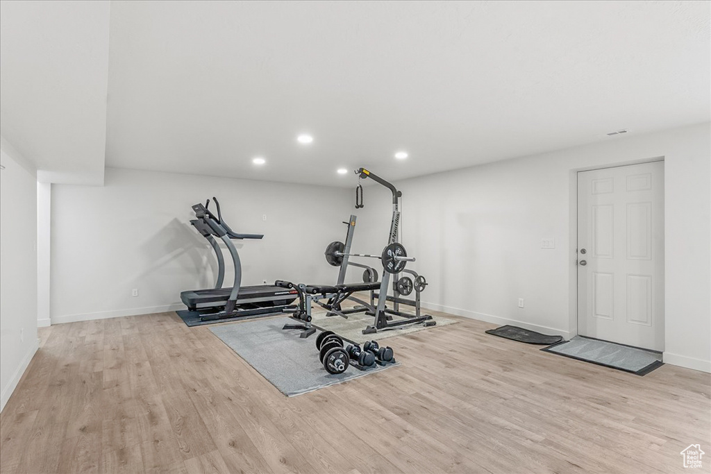 Workout area featuring light wood-type flooring