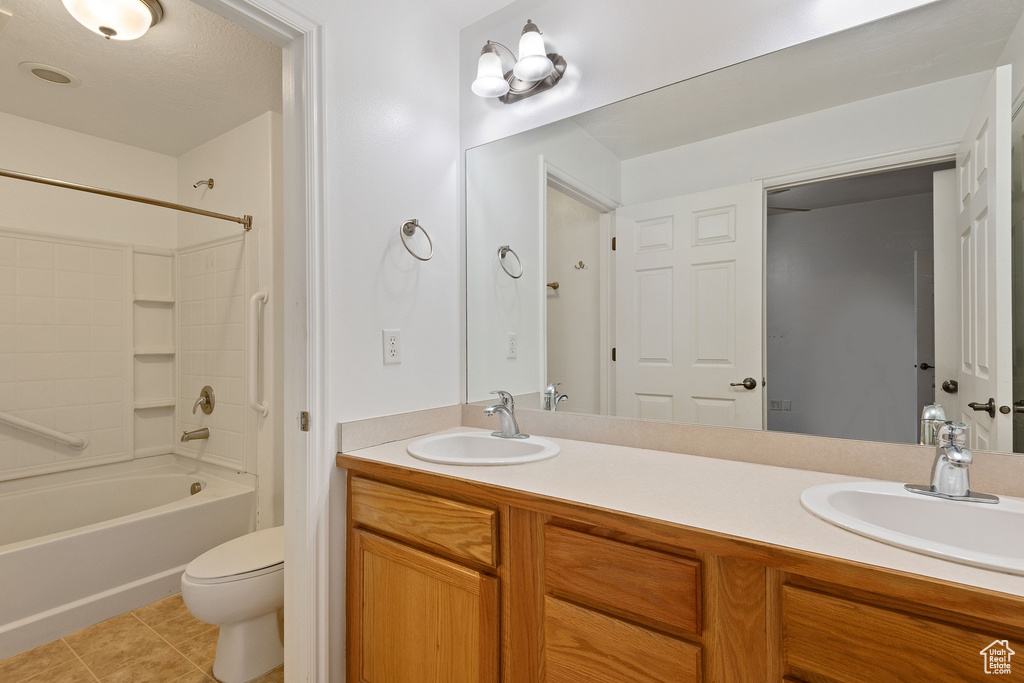 Full bathroom featuring bathing tub / shower combination, tile flooring, dual vanity, and toilet