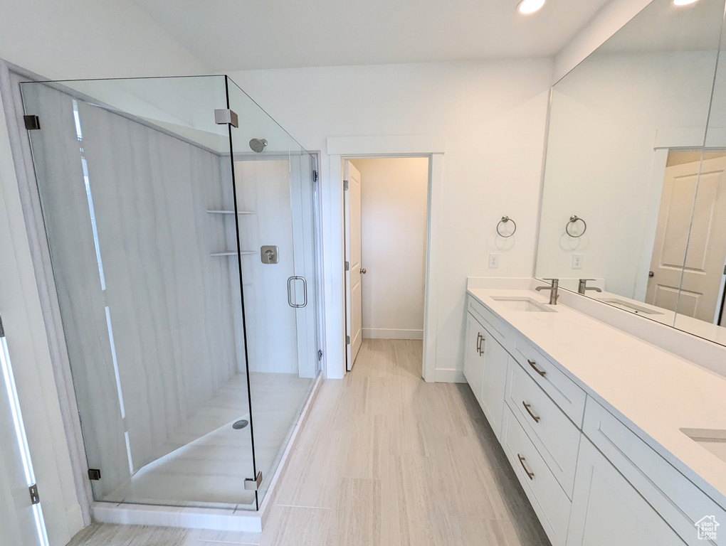 Bathroom featuring large vanity and an enclosed shower