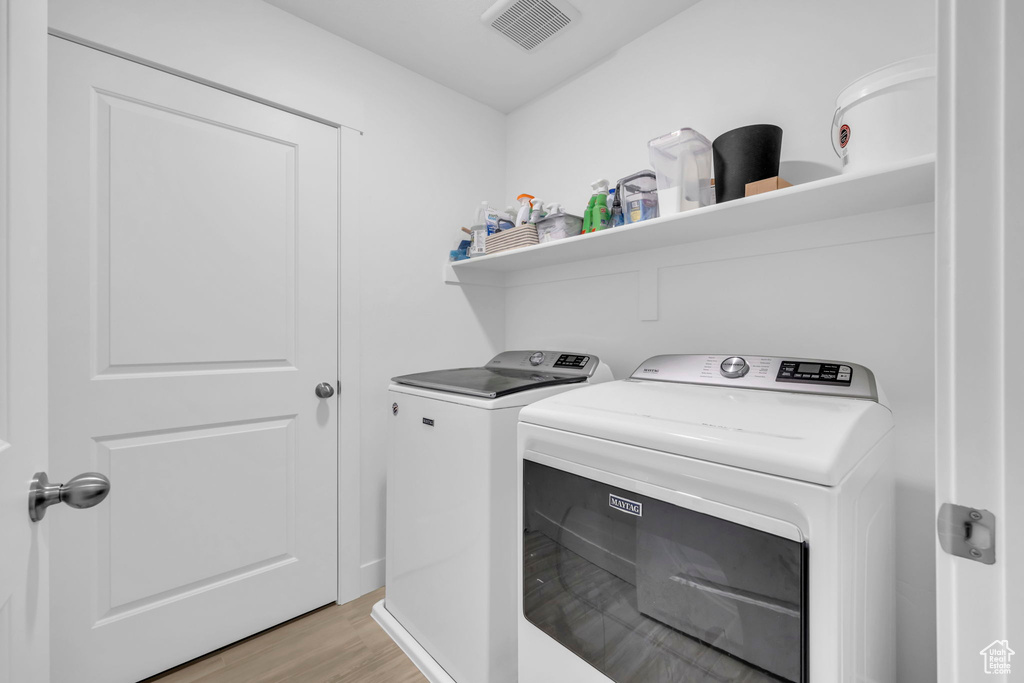 Laundry room featuring light hardwood / wood-style flooring and separate washer and dryer