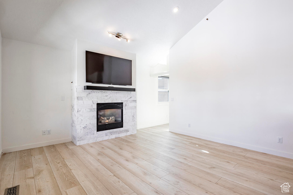 Unfurnished living room featuring light hardwood / wood-style floors and a fireplace