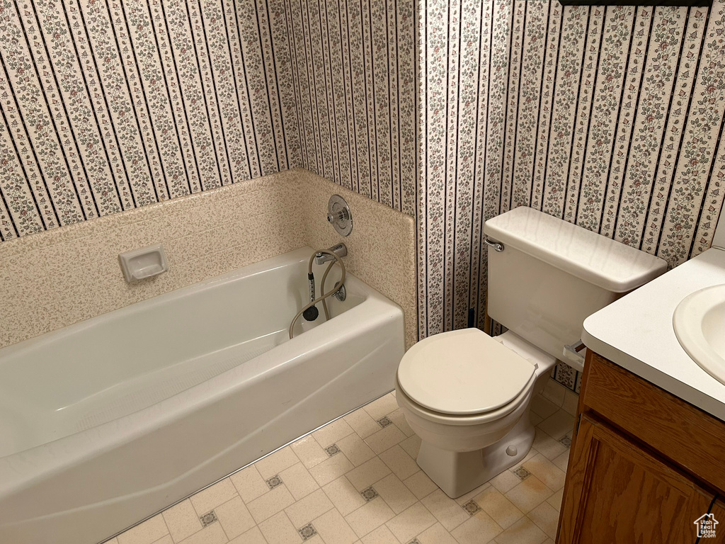 Bathroom with vanity, toilet, a tub, and tile flooring