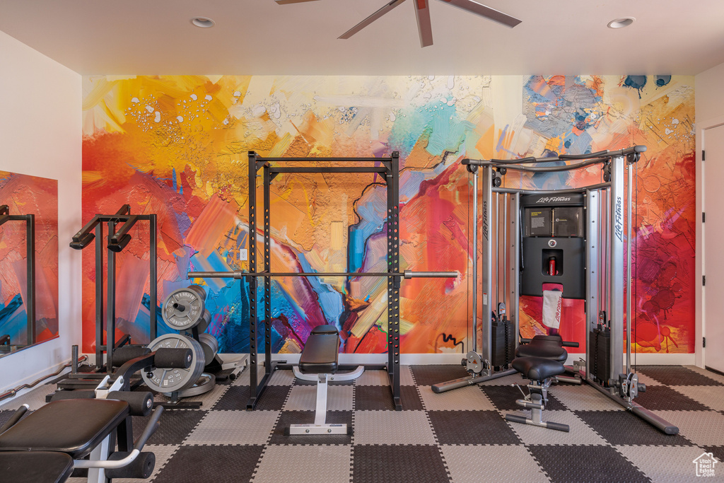 Workout area with ceiling fan and dark carpet