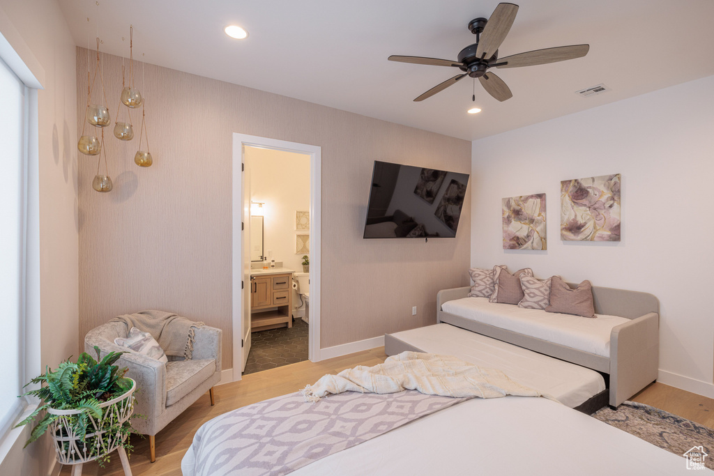 Bedroom featuring light tile floors, ensuite bathroom, and ceiling fan
